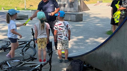 Dzielnicowi z Komisariatu Policji w Gdowie rozdają dzieciom odblaskowe kamizelki i elementy odblaskowe